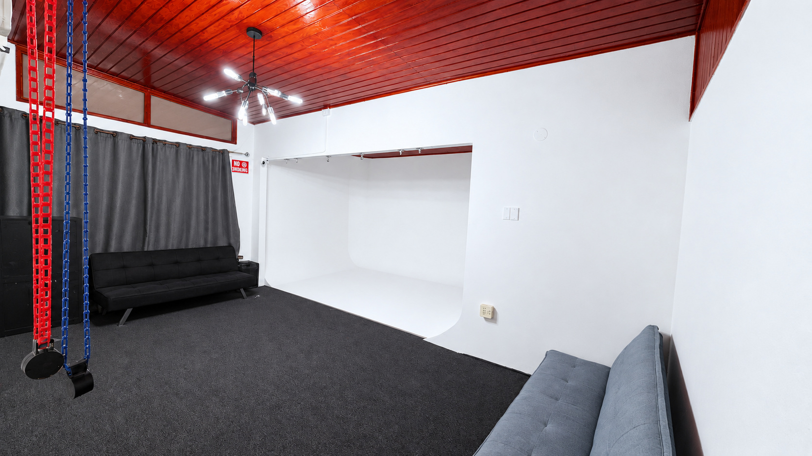 The 21 Dahlia studio with white cyc wall, grey shooting floor and seating beneath the wooden ceiling